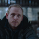 David is seen sitting in a wood shed and talking to someone off-screen.